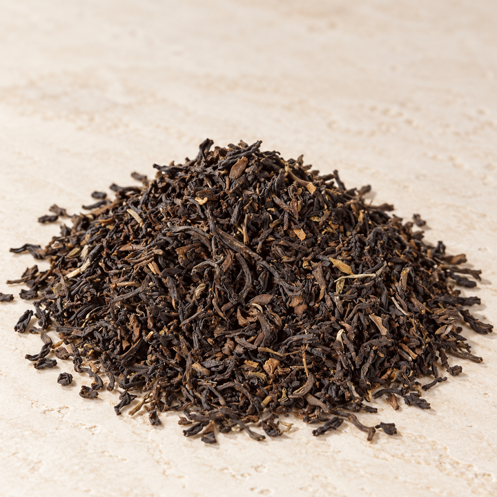 Darjeeling Margaret’s Hope – lose dunkle Teeblätter auf hellem Stein, nach Produktvorlage inszeniert